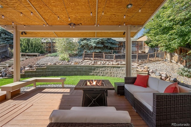 deck featuring an outdoor living space with a fire pit and a fenced backyard