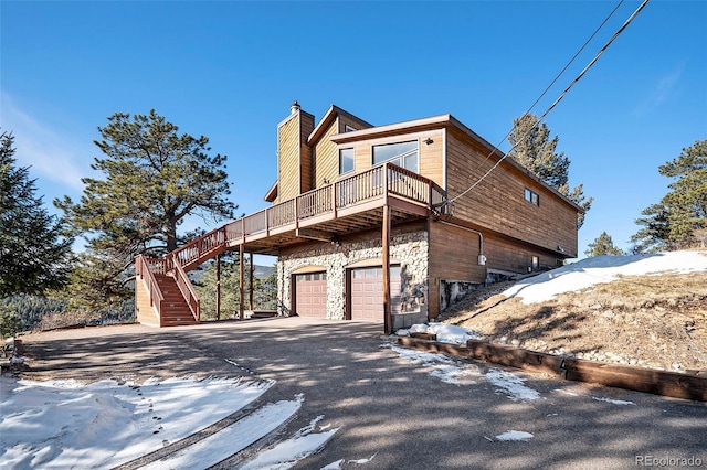 view of snowy exterior with a balcony and a garage