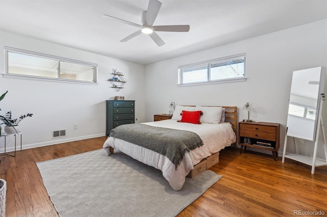 bedroom featuring a ceiling fan, baseboards, visible vents, and wood finished floors