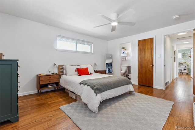 bedroom featuring a ceiling fan, baseboards, visible vents, and wood finished floors