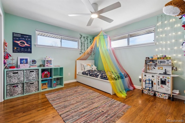 playroom featuring ceiling fan, baseboards, and wood finished floors