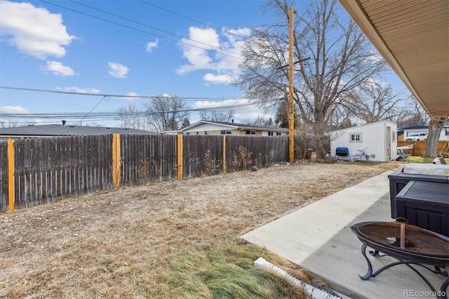 view of yard featuring a patio area, an outdoor structure, and a fenced backyard