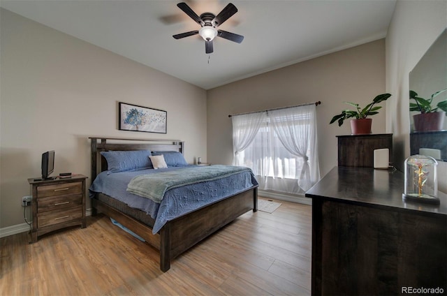 bedroom featuring a ceiling fan, light wood-style floors, and baseboards