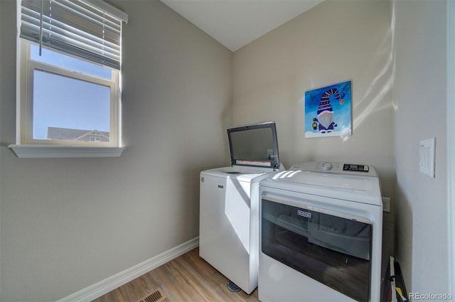 washroom with laundry area, baseboards, independent washer and dryer, and light wood-type flooring