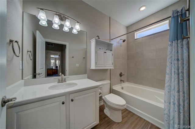 full bathroom featuring shower / bath combo with shower curtain, toilet, wood finished floors, and vanity