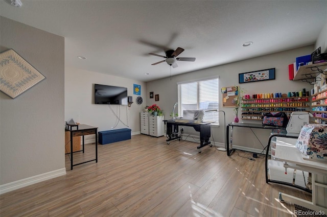 interior space featuring wood finished floors, baseboards, and ceiling fan