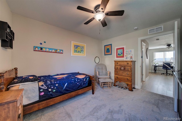 carpeted bedroom featuring visible vents, baseboards, and ceiling fan