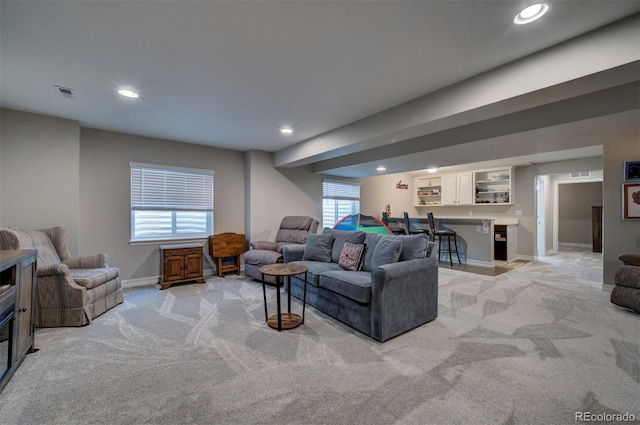 living area featuring recessed lighting, visible vents, light carpet, and baseboards