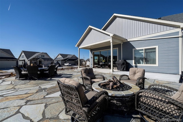 view of patio featuring outdoor dining space, a fire pit, and a residential view