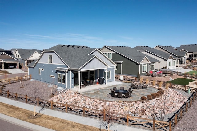 back of house with a patio area, a residential view, a fenced backyard, and roof with shingles