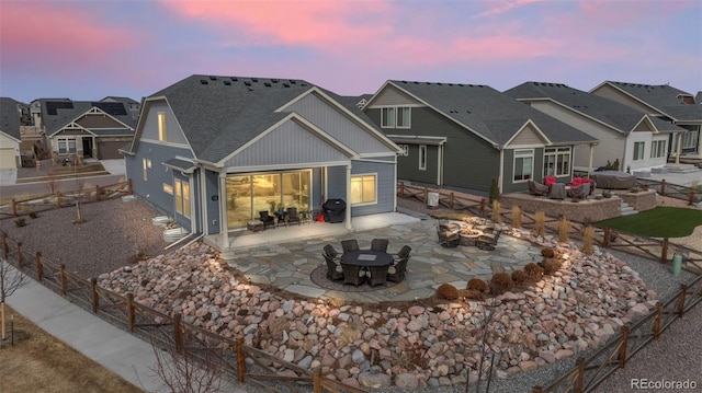 back of house featuring a patio area, a residential view, a fenced backyard, and a fire pit