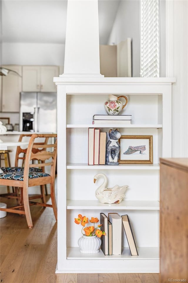 interior details featuring wood finished floors and white fridge with ice dispenser