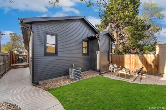 back of property featuring a deck, a fenced backyard, cooling unit, a patio, and a yard