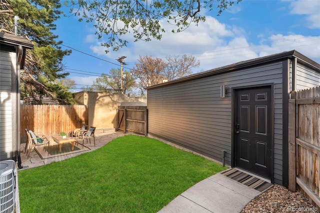 view of yard with fence, an outbuilding, cooling unit, and a patio area