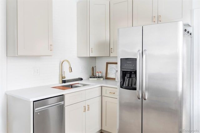 kitchen with light countertops, stainless steel appliances, a sink, and backsplash