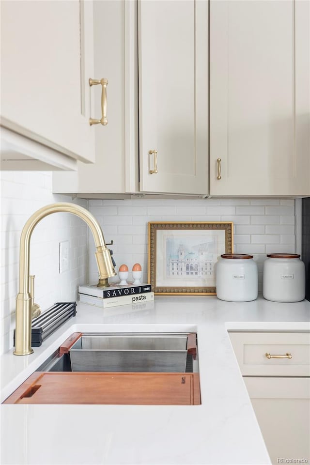details featuring light countertops, tasteful backsplash, and a sink