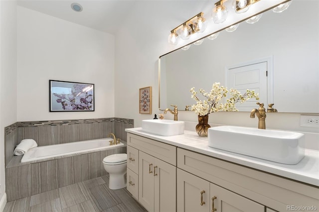 bathroom with double vanity, a sink, a bath, and toilet