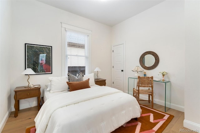 bedroom with light wood-style floors and baseboards
