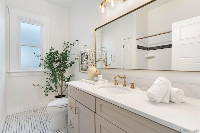 bathroom with walk in shower, vanity, toilet, tile patterned floors, and baseboards