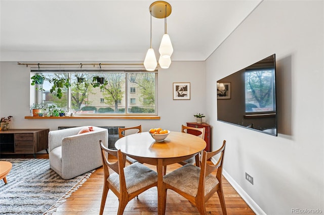 dining space featuring baseboards, a wealth of natural light, and wood finished floors