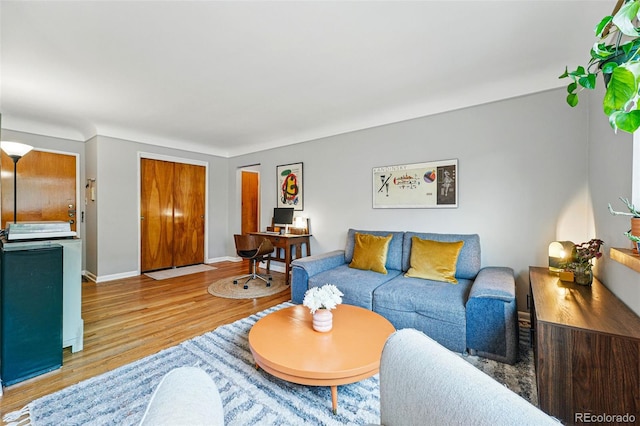 living area with baseboards and wood finished floors