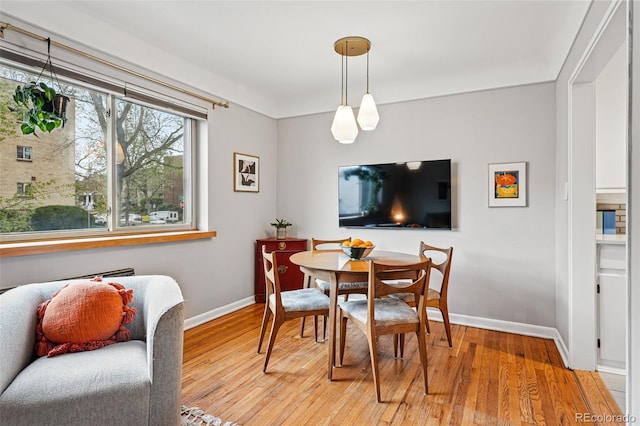 dining area with baseboards and light wood-style floors