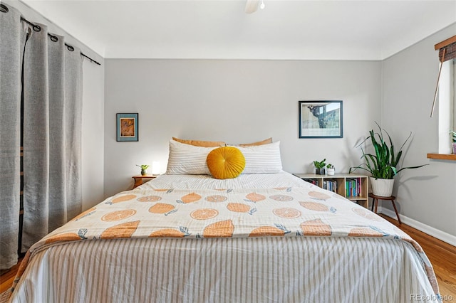 bedroom with baseboards and wood finished floors