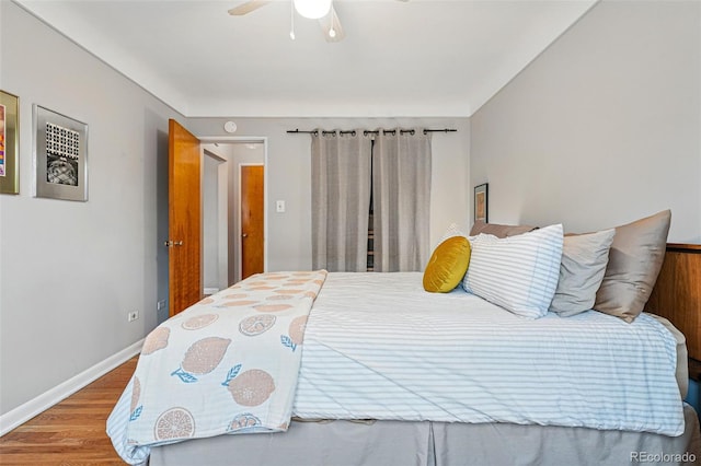 bedroom featuring baseboards, ceiling fan, and wood finished floors