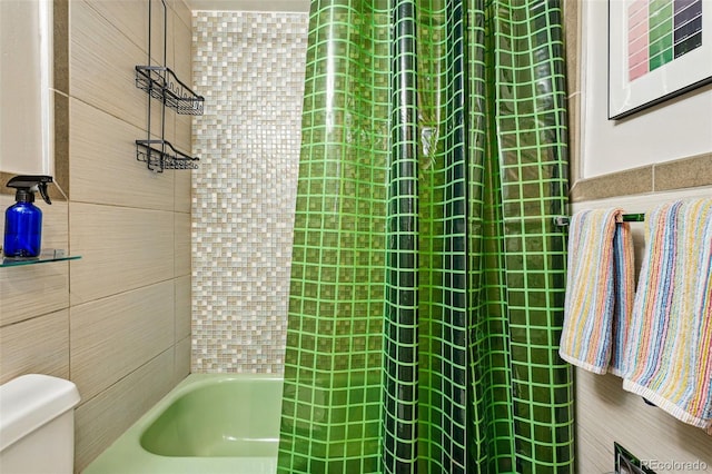 bathroom with tile walls and toilet