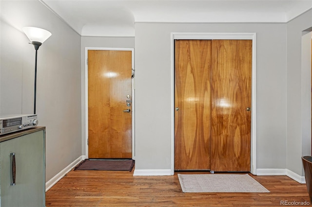 foyer with baseboards and wood finished floors