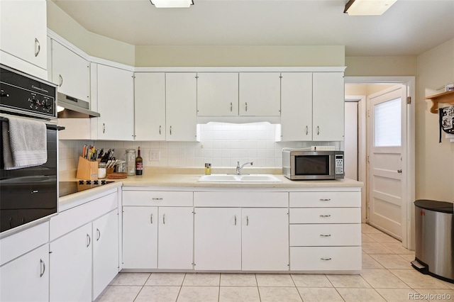 8250 Chase Way, Arvada, CO 80003 - kitchen with black appliances, range hood, tasteful backsplash, light countertops, and light tile patterned floors