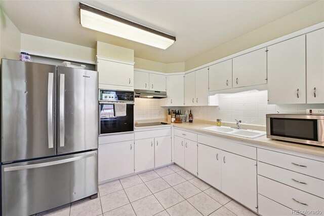 8250 Chase Way, Arvada, CO 80003 - kitchen featuring black appliances, under cabinet range hood, light countertops, light tile patterned flooring, and decorative backsplash