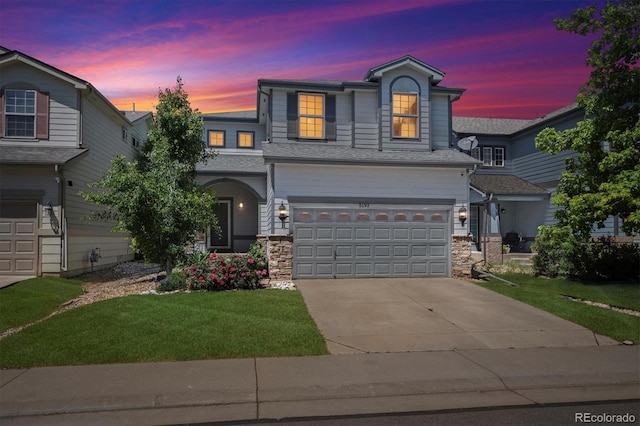 5193 E 119th Way, Thornton, CO 80233 - view of front of house featuring an attached garage, a front yard, driveway, and stone siding