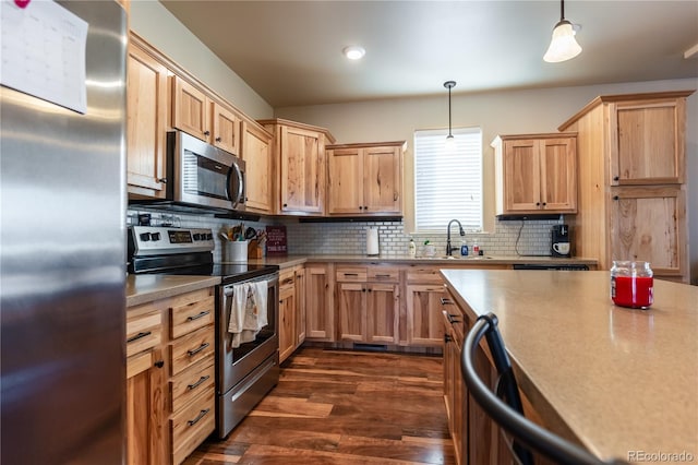 kitchen featuring sink, hanging light fixtures, appliances with stainless steel finishes, and tasteful backsplash