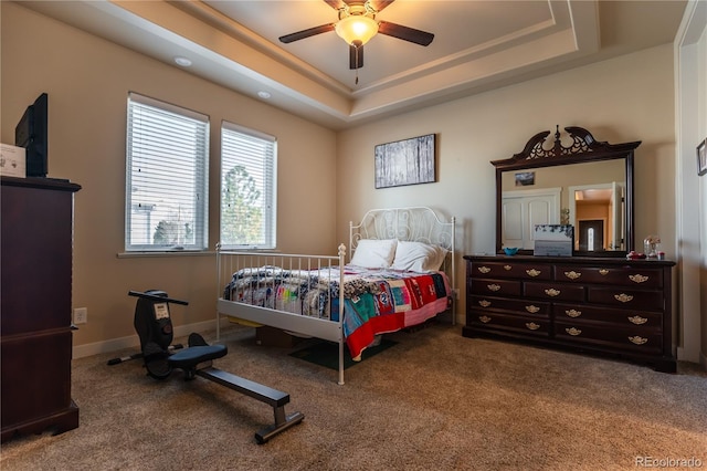 bedroom with ceiling fan, carpet, and a raised ceiling