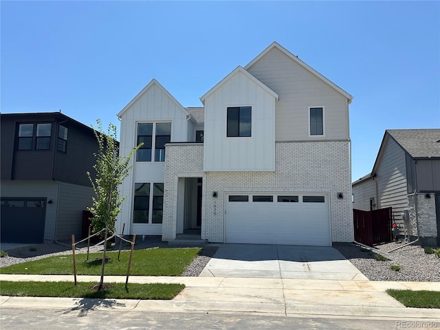 1625 Winter Glow Dr, Windsor, CO 80550 - modern home with brick siding, board and batten siding, a garage, and driveway