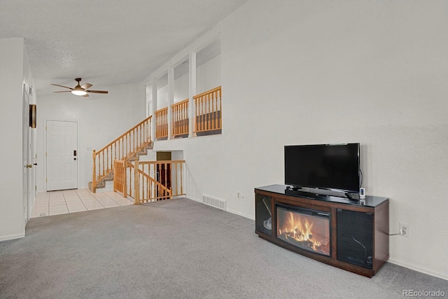 7784 Lewis St, Arvada, CO 80005 - unfurnished living room featuring carpet flooring, a ceiling fan, stairs, and tile patterned floors