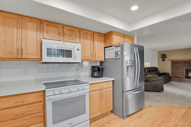 7784 Lewis St, Arvada, CO 80005 - kitchen featuring white appliances, open floor plan, light wood-type flooring, and light countertops