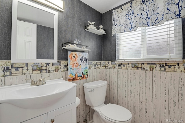7784 Lewis St, Arvada, CO 80005 - half bath featuring vanity, a wainscoted wall, and wallpapered walls