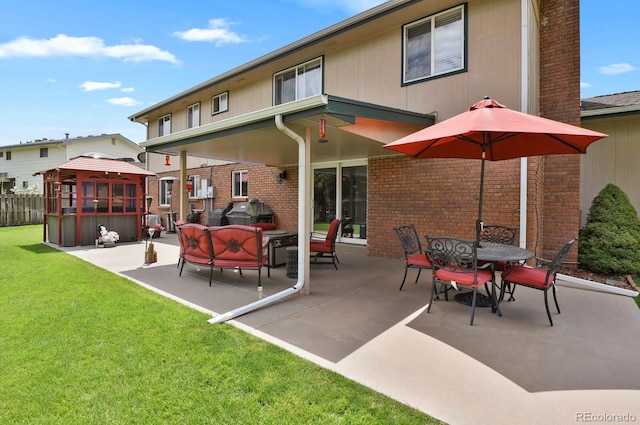 7784 Lewis St, Arvada, CO 80005 - rear view of house with a patio area, brick siding, outdoor dining space, outdoor lounge area, and a gazebo