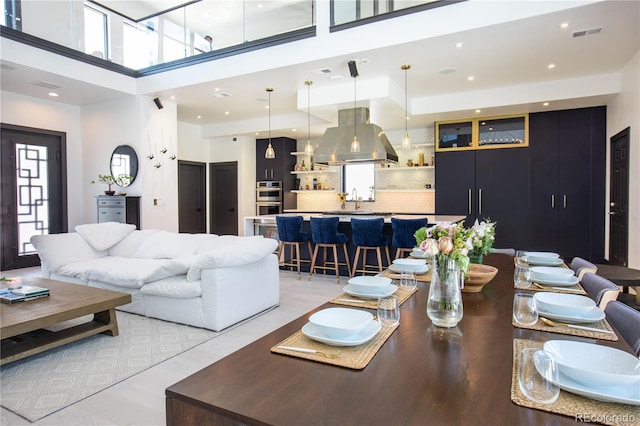 living room featuring a wealth of natural light, light hardwood / wood-style floors, and a high ceiling