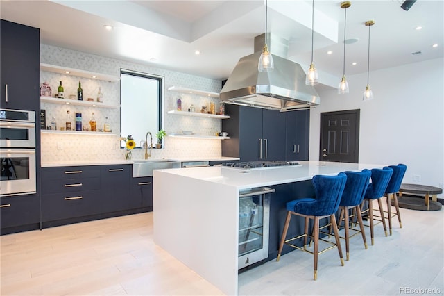 kitchen with island exhaust hood, tasteful backsplash, stainless steel appliances, sink, and a kitchen island