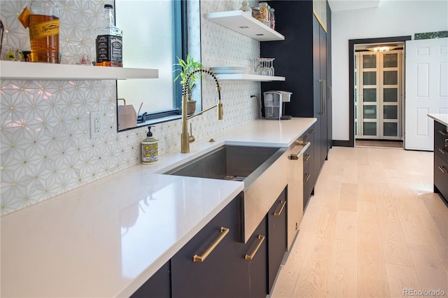 kitchen with light hardwood / wood-style floors, sink, and backsplash