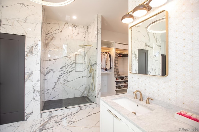 bathroom with a shower, vanity, and tile walls