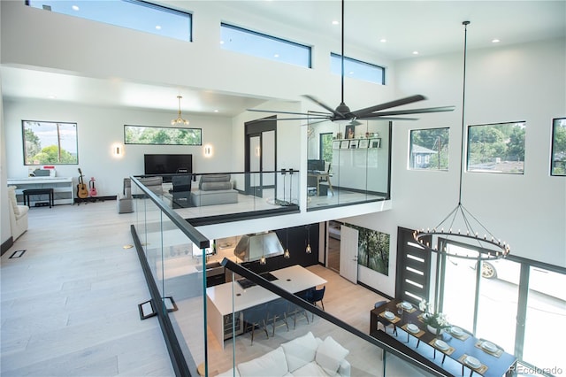 interior space featuring light hardwood / wood-style flooring, a high ceiling, and a notable chandelier