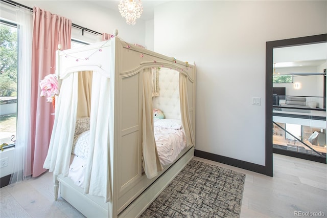 bedroom featuring a chandelier and light hardwood / wood-style flooring