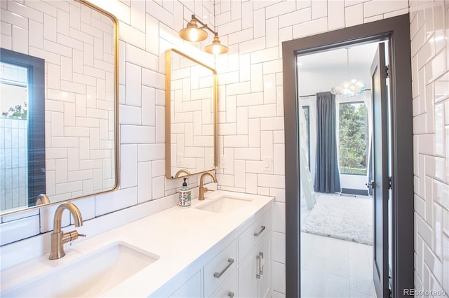 bathroom featuring vanity, a chandelier, and tile walls