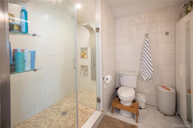 bathroom with an enclosed shower, toilet, and tile walls