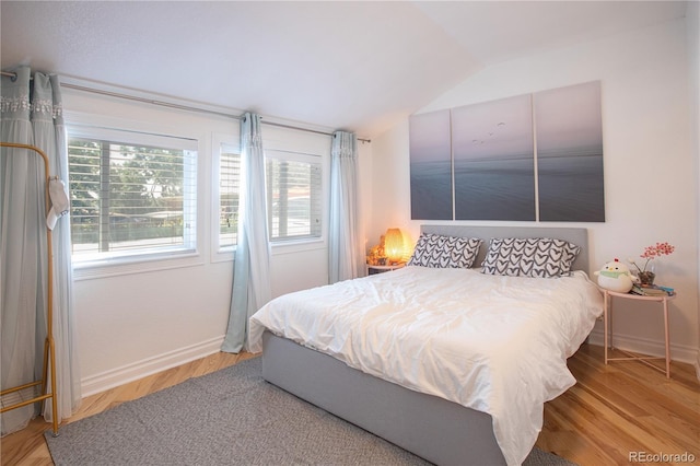 bedroom with hardwood / wood-style floors and lofted ceiling