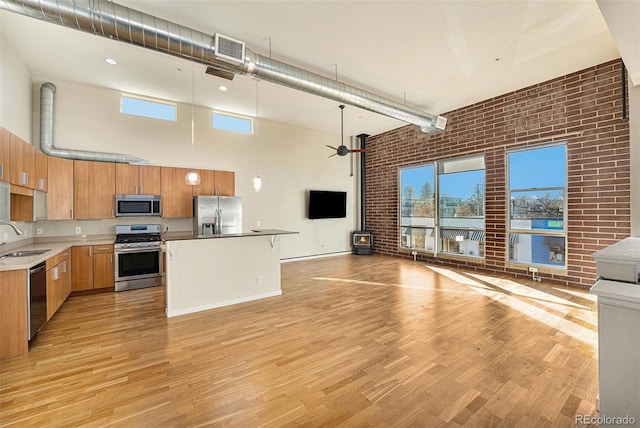 4258 Tennyson St Unit 104, Denver, CO 80212 - kitchen with appliances with stainless steel finishes, a high ceiling, open floor plan, light wood-type flooring, and ceiling fan